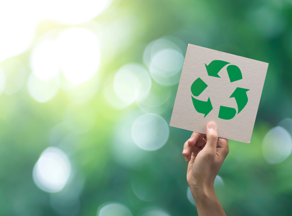 Hand holding a recycling symbol representing sustainable recycling and environmental responsibility.